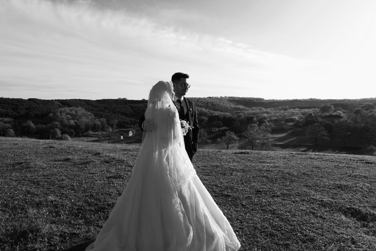 Bride and groom walking on a hillside at golden hour