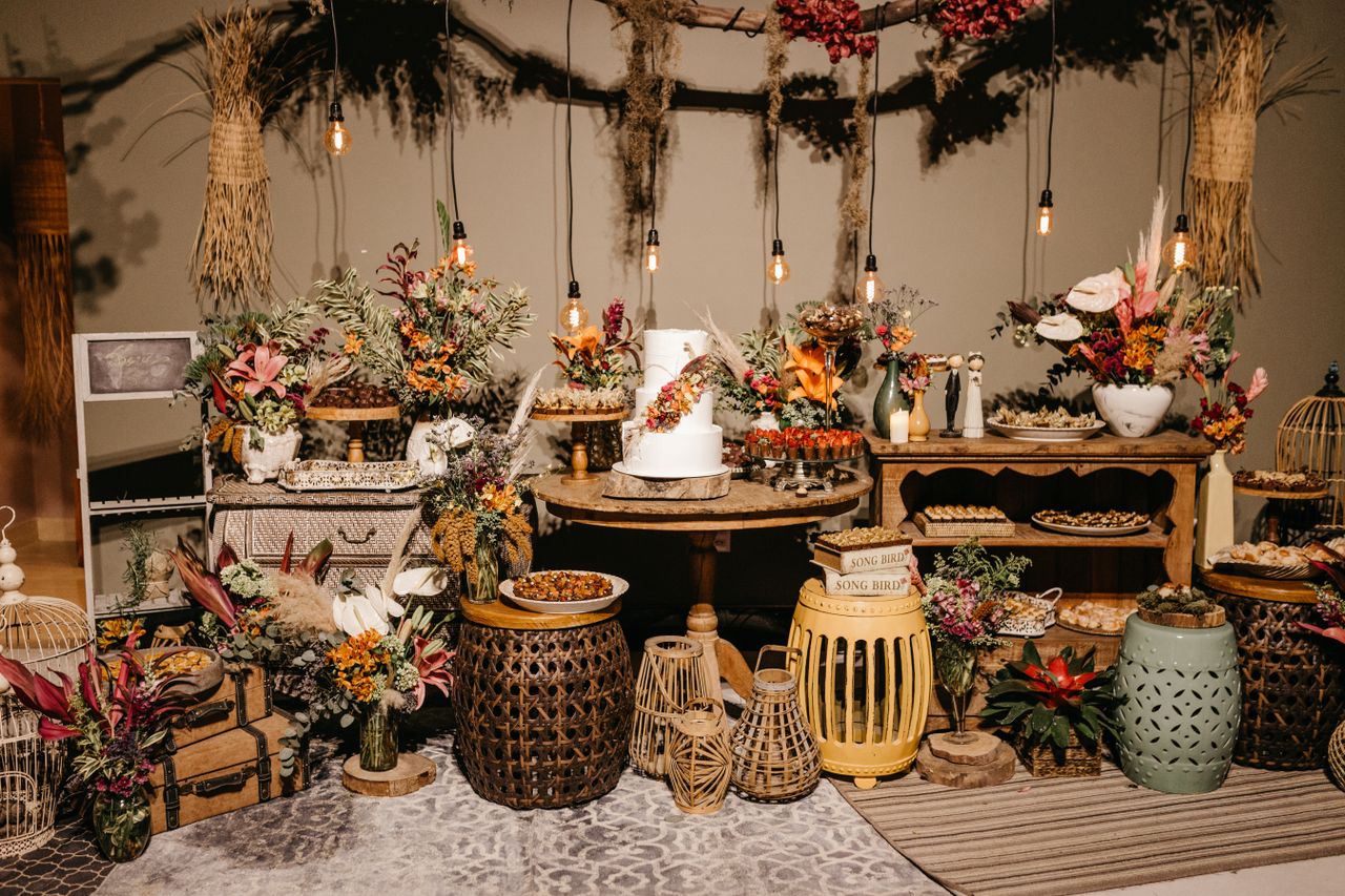 Rustic wedding dessert table with Edison bulb lights and florals